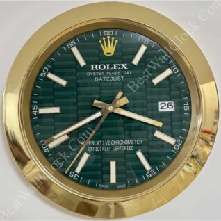 Round wall clock designed like a Rolex Oyster Perpetual Datejust watch face with a green patterned dial, gold frame, gold hour and minute hands, white hour markers, and a date window showing 26, with the text 'Rolex Oyster Perpetual Datejust Superlative Chronometer Officially Certified Swiss Made' on the dial.