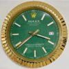Rolex wall clock with a green face, gold fluted bezel, white and gold hour markers, gold hour and minute hands, and a date window showing 11, displaying the time as 3:39.