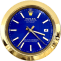 Close-up of a Rolex Oyster Perpetual Datejust watch face with a blue dial, gold hour markers and hands, a gold bezel, and a date display showing the number 4.