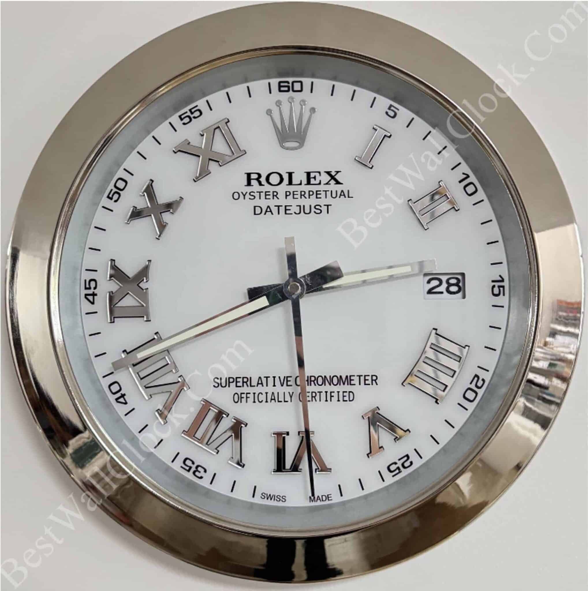 Round Rolex clock with white face, silver Roman numerals, and a date window showing 28, encased in a shiny silver frame with minute markers on the outer edge.