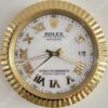 Gold-framed Rolex wall clock with Roman numerals, white face, and black text reading 'Rolex Oyster Perpetual Datejust Superlative Chronometer Officially Certified', showing the time 8:21:38 and date 17.