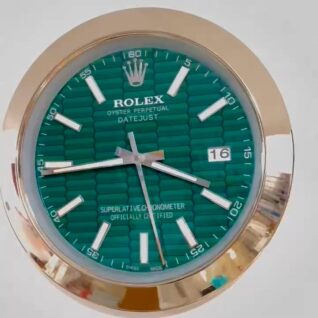 Close-up of a Rolex Oyster Perpetual Datejust watch face with a green textured dial, silver hour markers, and a date window showing 16, encased in a gold-toned bezel.