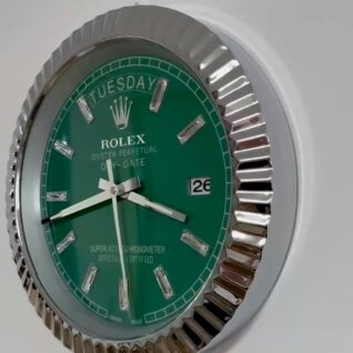 Close-up of a green Rolex Oyster Perpetual Day-Date wall clock with silver hour markers and a fluted silver bezel, showing the time as 9:15 and the date as the 26th on a white background.