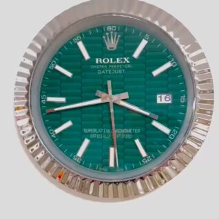 Rolex Oyster Perpetual Datejust watch face with green textured dial, silver-tone hour markers and hands, and date window showing 16, surrounded by a fluted silver bezel