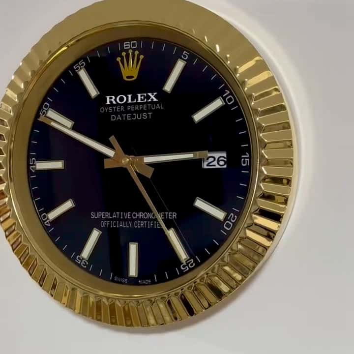 Close-up of a Rolex Oyster Perpetual Datejust watch face with a black dial, gold bezel, and white hour markers, showing the date as 26 and the time around 2:50:27.