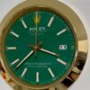 Close-up of a Rolex Oyster Perpetual Datejust watch with a green face, gold bezel, white hour markers, and a date display showing the number 11.