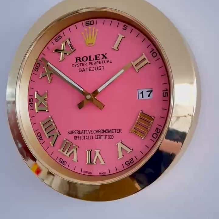 Rolex Oyster Perpetual Datejust watch with a pink face, gold Roman numerals, gold case, and date display showing the 17th