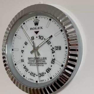 Close-up of a Rolex Sky-Dweller wall clock with a white face, silver fluted bezel, black hour markers, and date display showing the 28th.