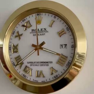 Close-up of a gold Rolex Oyster Perpetual Datejust clock with Roman numerals, showing the time as approximately 3:39:00 and the date as 17, against a white background.