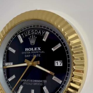 Close-up of a Rolex Oyster Perpetual Day-Date watch with a gold fluted bezel, black dial, diamond hour markers, showing the day as Tuesday and the date as 17
