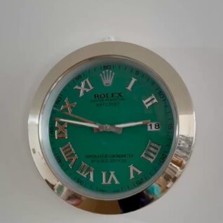 Close-up of a Rolex green wall clock with silver Roman numerals and hands, displaying the time 02:48 and date 18, mounted on a white wall.