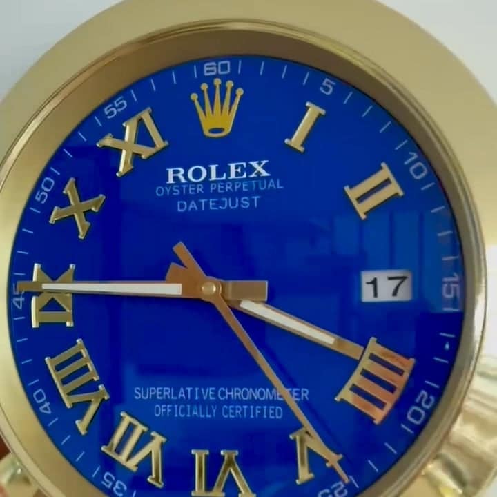 Close-up of a Rolex Oyster Perpetual Datejust watch with a blue dial, gold Roman numeral hour markers, gold hands showing the time as 9:45:24, and a date window displaying the number 17.