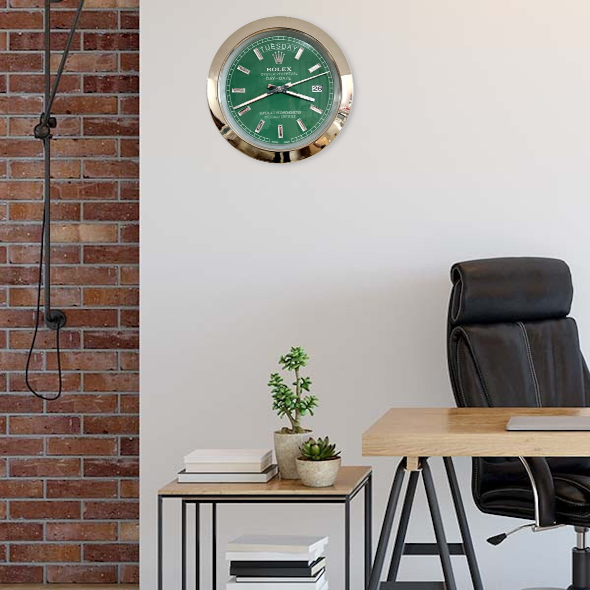 Modern office corner with a black leather chair, wooden desk, small side table with books and potted plants, brick accent wall on the left, and a green Rolex wall clock showing terça-feira 3:15 with the date 26 on a plain white wall