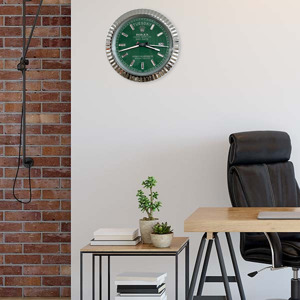 Modern office corner with a black leather chair, wooden desk, side table with potted plants and books, and a wall clock with a green Rolex dial displaying terça-feira the 26th against a white and brick wall background