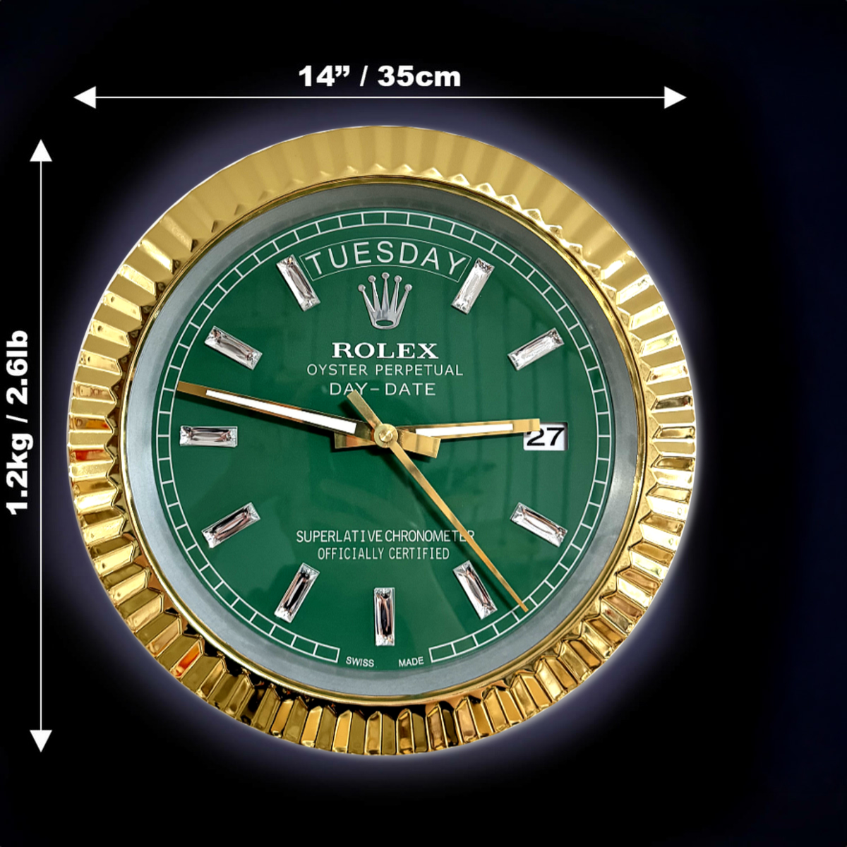 Close-up of a Rolex Oyster Perpetual Day-Date watch face with a green dial, gold fluted bezel, and diamond hour markers, showing the day as Dinsdag and the date as 27, with dimensions and weight annotations.