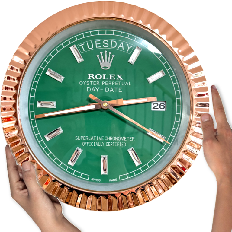 Hand holding a large Rolex Oyster Perpetual Day-Date wall clock with a green face, gold accents, and displaying Tuesday the 26th