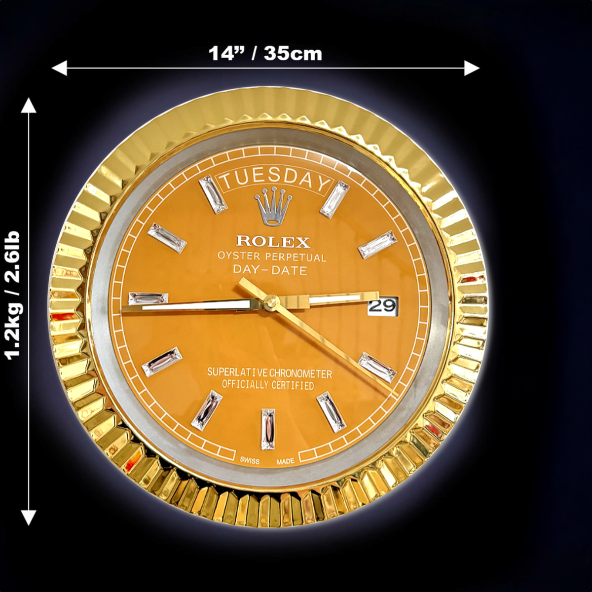Close-up of a gold Rolex Oyster Perpetual Day-Date clock face with diamond hour markers, showing the day as Tuesday and the date as 29, set against a black background with measurements indicating 14 inches (35 cm) diameter and weight of 1.2 kg (2.61 lb)