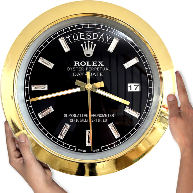 Close-up of hands holding a gold-rimmed black Rolex Oyster Perpetual Day-Date clock displaying Tuesday and the 17th with gold hour, minute, and second hands.