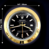 Black Rolex Oyster Perpetual Day-Date wall clock with gold rim, diamond-like hour markers, and gold hands, showing the day Tuesday and date 17, with dimensions 14 inches (35 cm) in diameter and 1.2 kg (2.61 lb) weight indicated