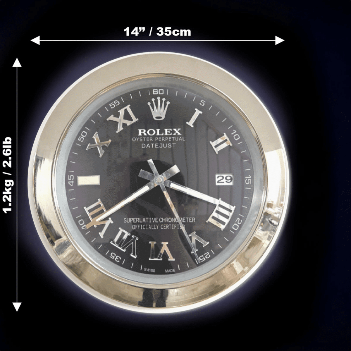 Rolex Oyster Perpetual Datejust clock with Roman numerals on a black face and a gold-tone bezel, showing size dimensions of 14 inches (35 cm) diameter and weight of 1.2 kg (2.61 lb).