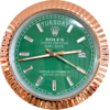 Close-up of a Rolex Oyster Perpetual Day-Date watch with a green dial, displaying the day as Tuesday and the date as 26, featuring a rose gold fluted bezel and diamond hour markers.