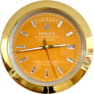 Close-up of a gold-framed Rolex Oyster Perpetual Day-Date watch with an orange dial showing the day as Tuesday and the date as 29.