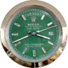 Rolex Oyster Perpetual Day-Date watch face with green dial, silver hour markers, and day and date display showing terça-feira and 26, surrounded by a shiny metallic bezel.