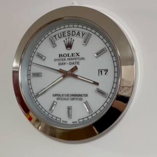 Close-up of a Rolex Oyster Perpetual Day-Date watch face showing Dinsdag and the date 17, with silver hour markers and hands on a white dial inside a silver bezel.